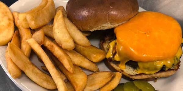 Cheeseburger with thick fries and pickles at Hereford & Hops Restaurant Bar Brewery Escanaba.